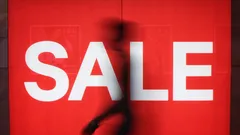 Red background with large white SALE text and blurred person walking by
