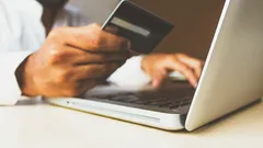 Person making online payment using credit card and laptop