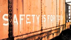 Rusty train car with faded white text safety is for fools
